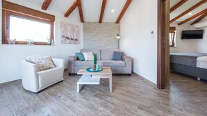 Ein modernes Wohnzimmer mit einer Couch, einem Couchtisch und einem Fernseher.