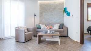 Ein modernes Wohnzimmer mit einer Couch, einem Sessel und einem Couchtisch.