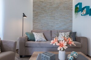 Apartament superior, balcó, vistes al mar | Sala d'estar | Televisor LED de 81 cm amb canals per satèl·lit i televisor 