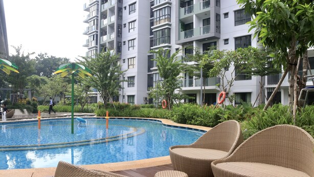 A swimming pool with wicker lounge chairs and a safety ring. - Spacious and Modern Service Apartment in Hochiminh (Ho Chi Minh City)