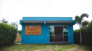 A modern building with a blue exterior and a wooden sign that reads "RECANTO VERTENTES". - Pousada Recanto das Vertentes (Capitólio)