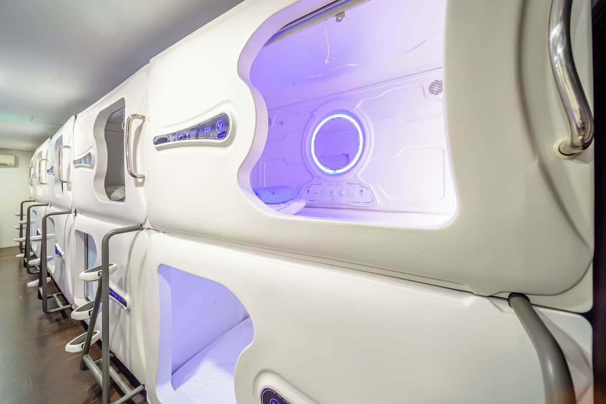 A row of modern, white, reclining chairs with built-in lighting and control panels.