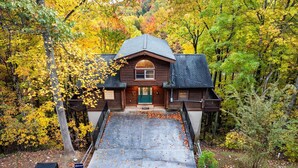 Eine Blockhütte mit Veranda, umgeben von Herbstlaub.