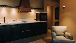 Una cocina moderna con vigas de madera en el techo, horno empotrado y pileta.