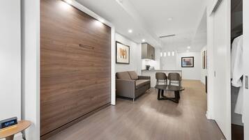 A modern living room with a sofa, chairs, a coffee table, and a wooden sliding door.