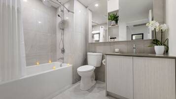 Une salle de bain moderne équipée d’une baignoire, de toilettes et d’une douche.