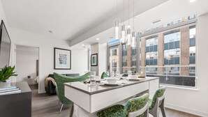 A modern kitchen with a central island, pendant lights, and a view of the city through large windows. - reStays Ottawa (Ottawa)
