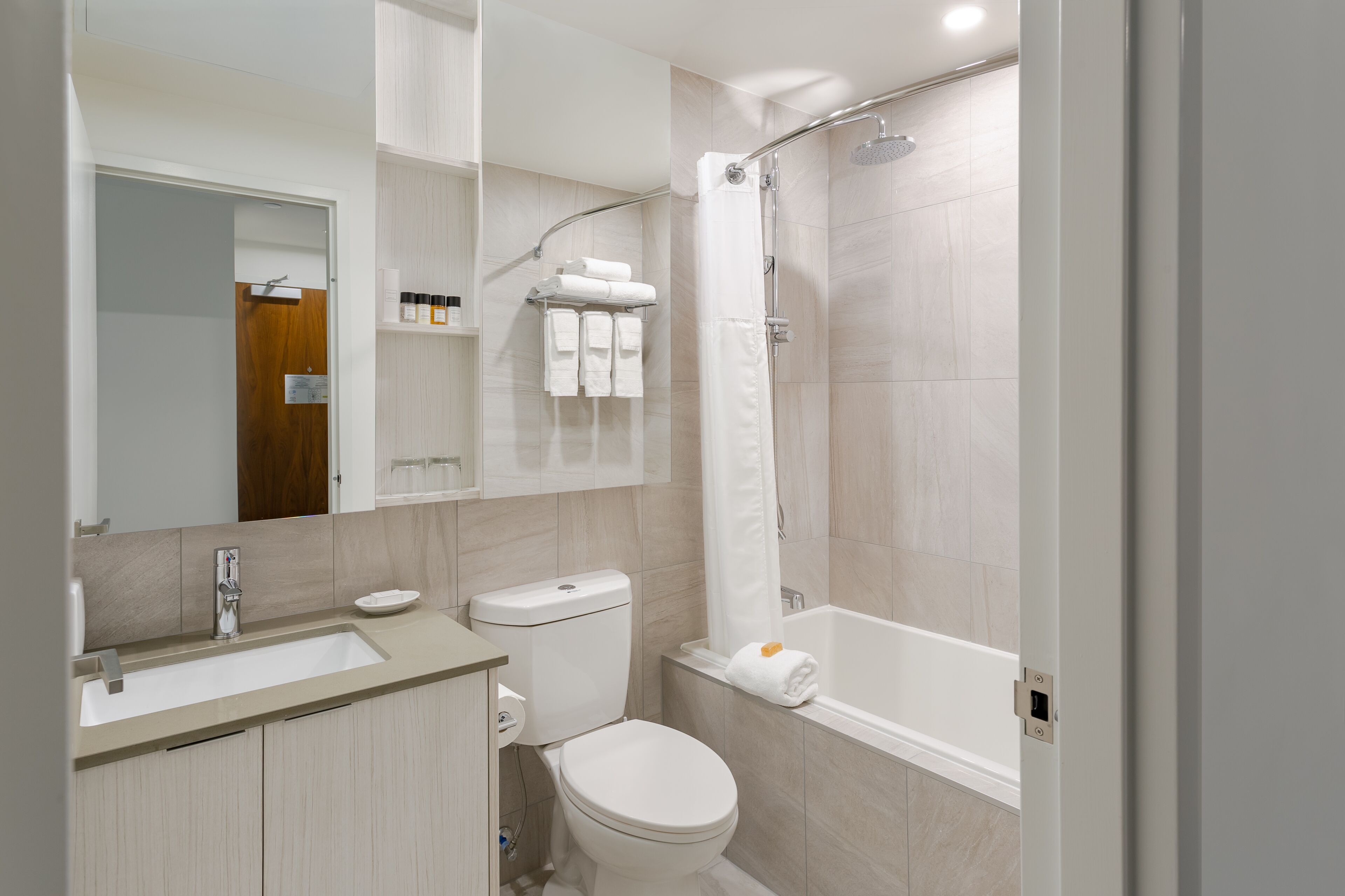A modern bathroom with a sink, toilet, and bathtub.