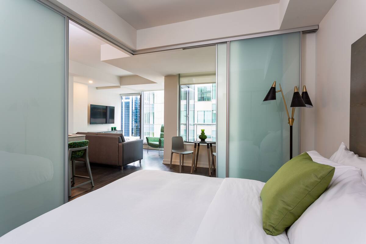 Une chambre d’hôtel moderne équipée d’un lit, d’un bureau, d’une chaise et offrant une vue sur la ville.