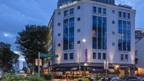 Un hotel moderno con techo plano y ventanas amplias, situado en una esquina.