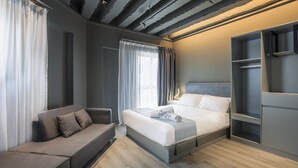 Una habitación de hotel moderna con una cama, un sofá y un armario empotrado.