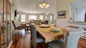 A dining area with a wooden table, chairs, and a chandelier. - Enchanting 3 BR, minutes from Winerys, Snow Sking, exhilarating Rafting Tours. (Medford)
