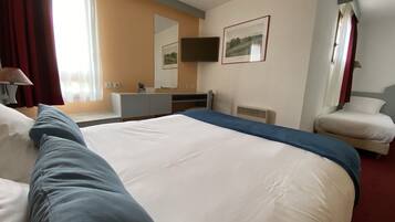 A hotel room with a large bed, a desk, a chair, a television, and a window with curtains.