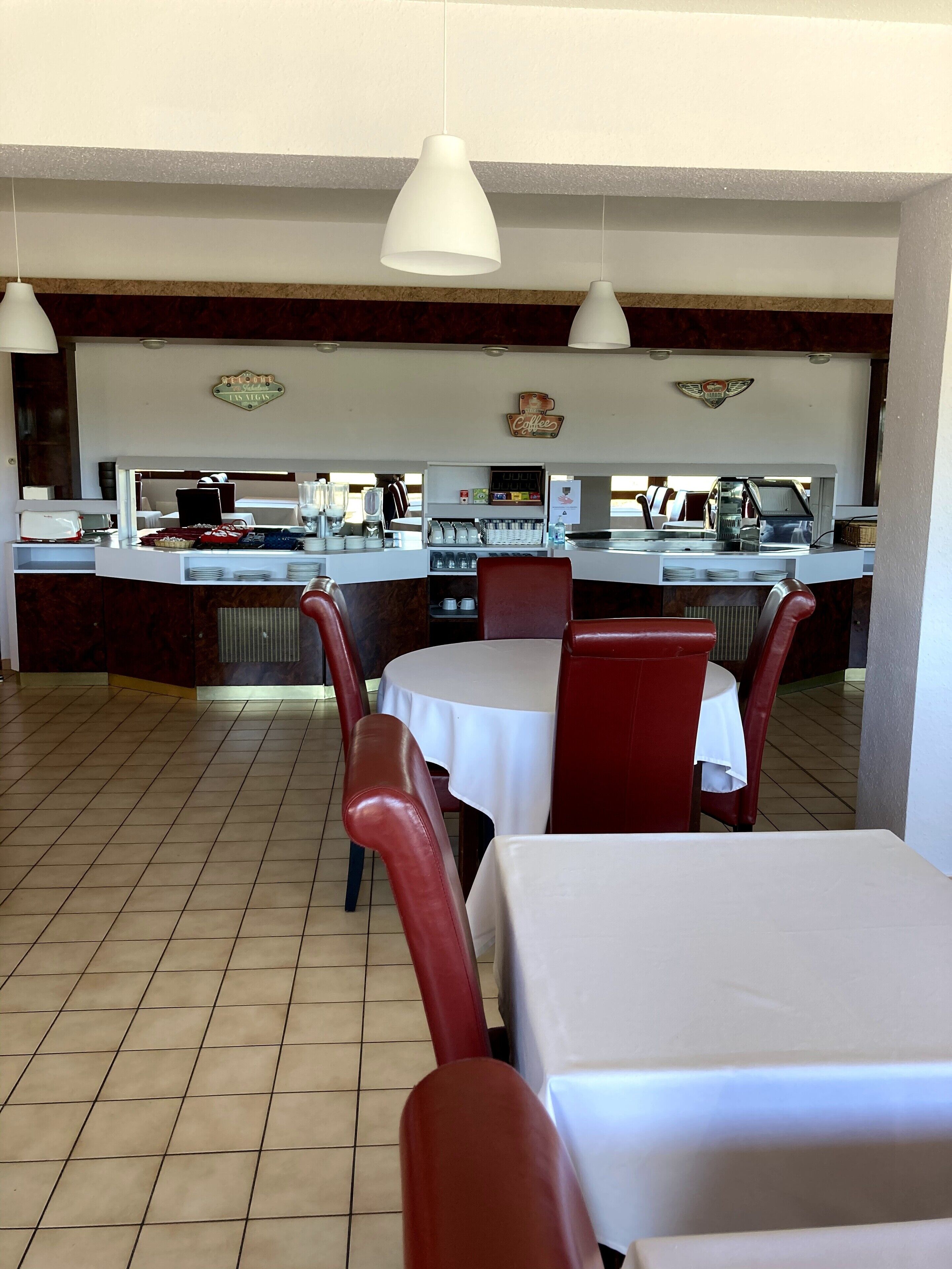 En restaurang med en bardisk, bord och stolar.