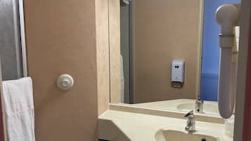 Un baño pequeño con inodoro, lavabo y espejo.