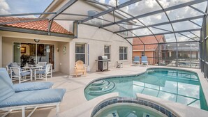 Une piscine extérieure couverte, dotée de chaises longues, d’un barbecue et d’un espace patio.