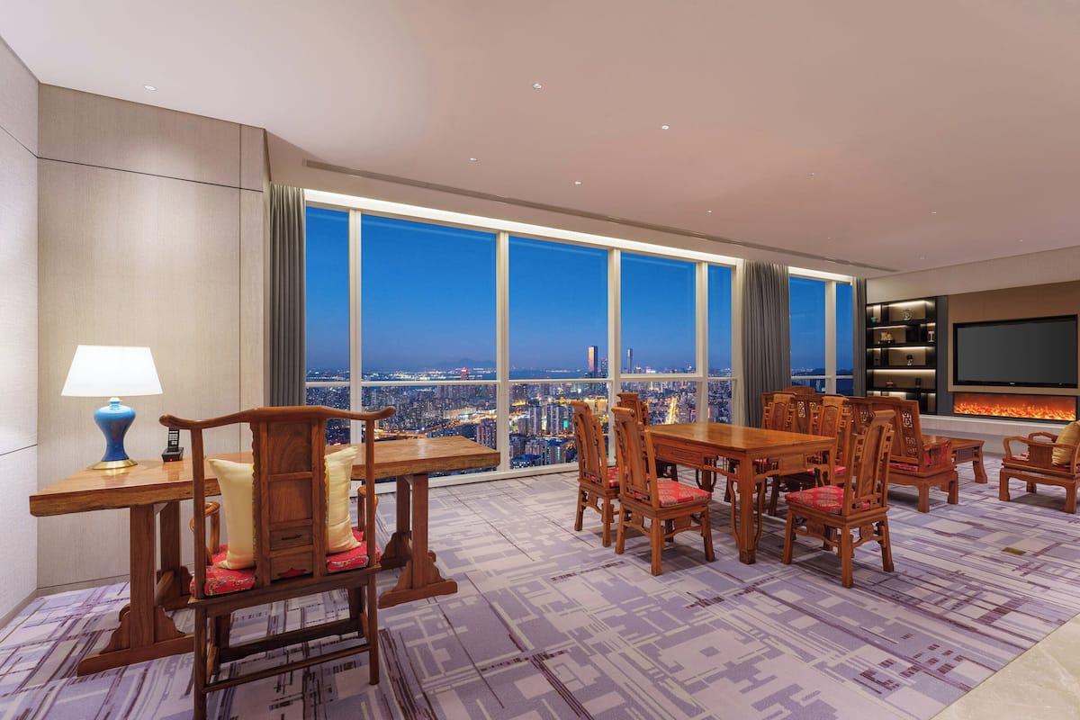 Ein geräumiges Wohnzimmer mit Blick auf die Stadt, einem Kamin und einem Fernseher.