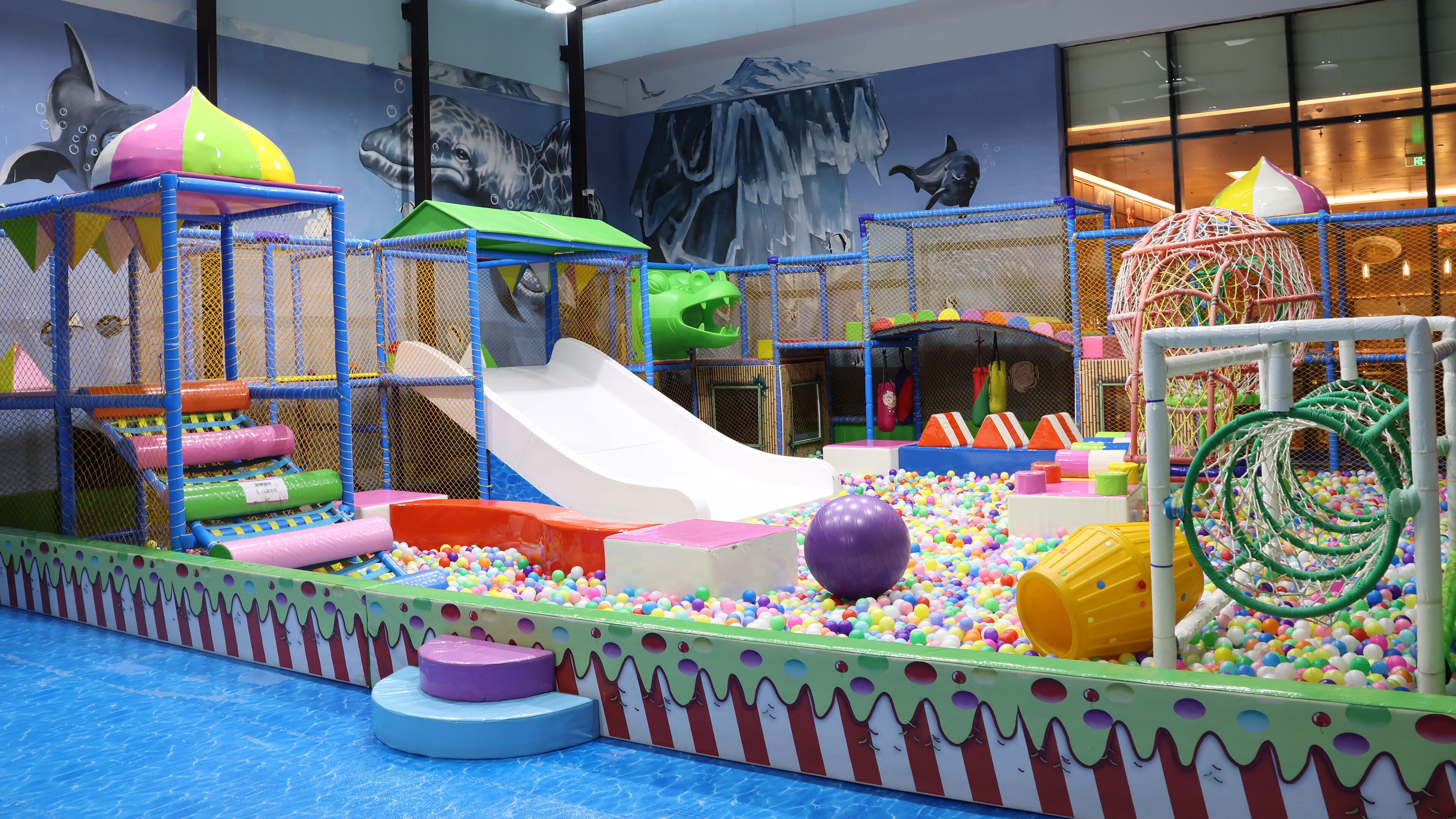 An indoor play area with a slide, ball pit, and various play structures.