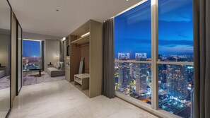 Une chambre d’hôtel moderne offrant une vue imprenable sur la ville, un coin salon confortable et un design minimaliste.