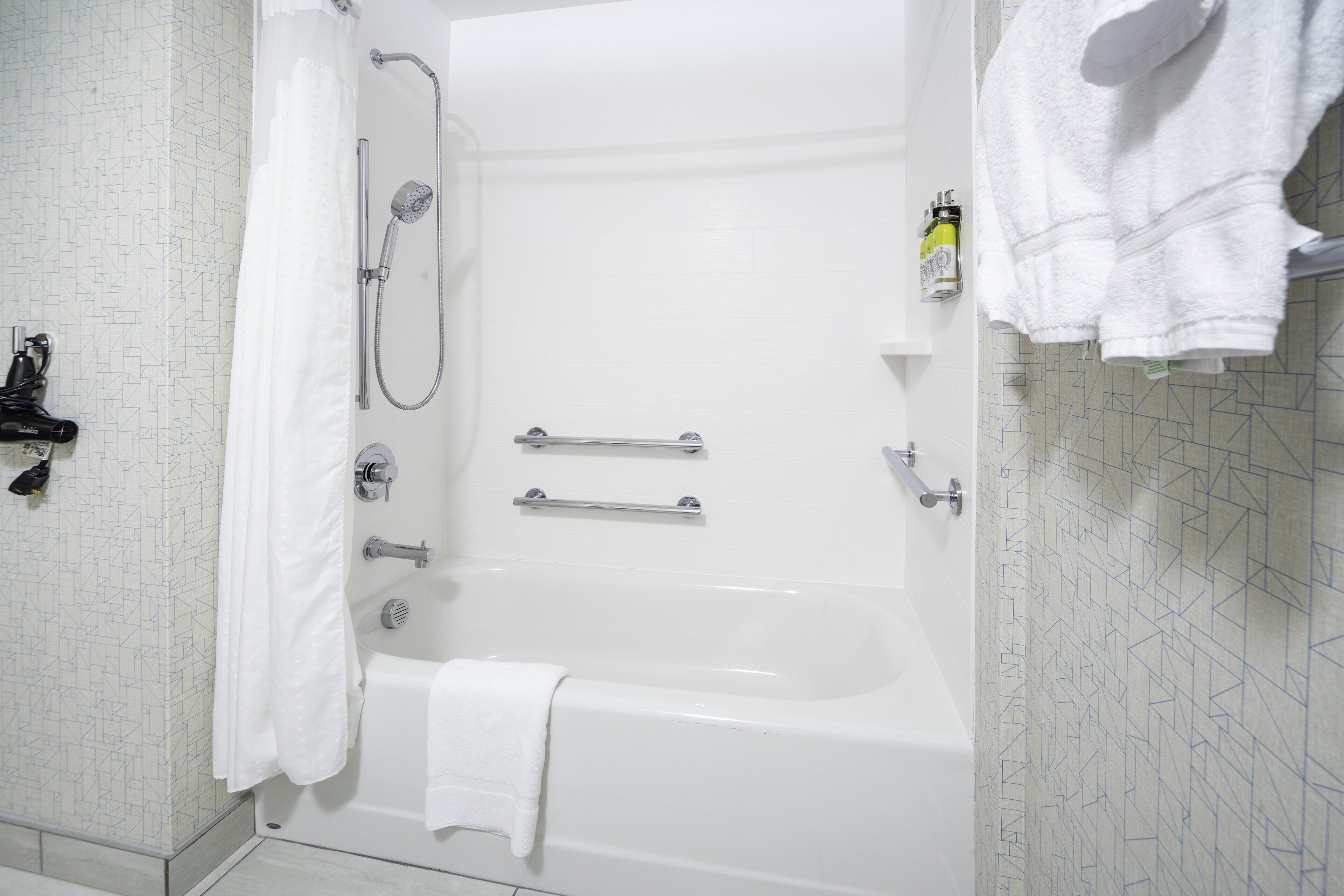 Un baño moderno con bañera, ducha y toallero.