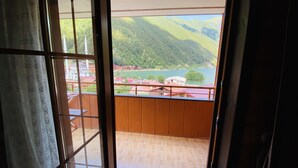 A balcony with a view of a lake and mountains.