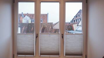 A window with three panels and a view of buildings outside.