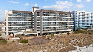 A modern hotel with multiple floors, large windows, and a flat roof. - Oceanfront w/ Elevator, Indoor Pool/Hot tub (North Myrtle Beach)