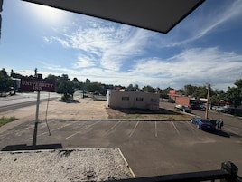 Un estacionamiento con un letrero que dice 'Greeley University Inn' y un pequeño edificio a lo lejos.
