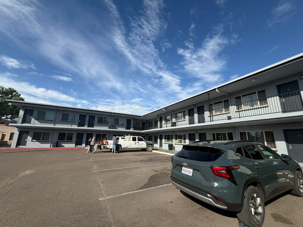 A multi-story building with a parking lot in front.