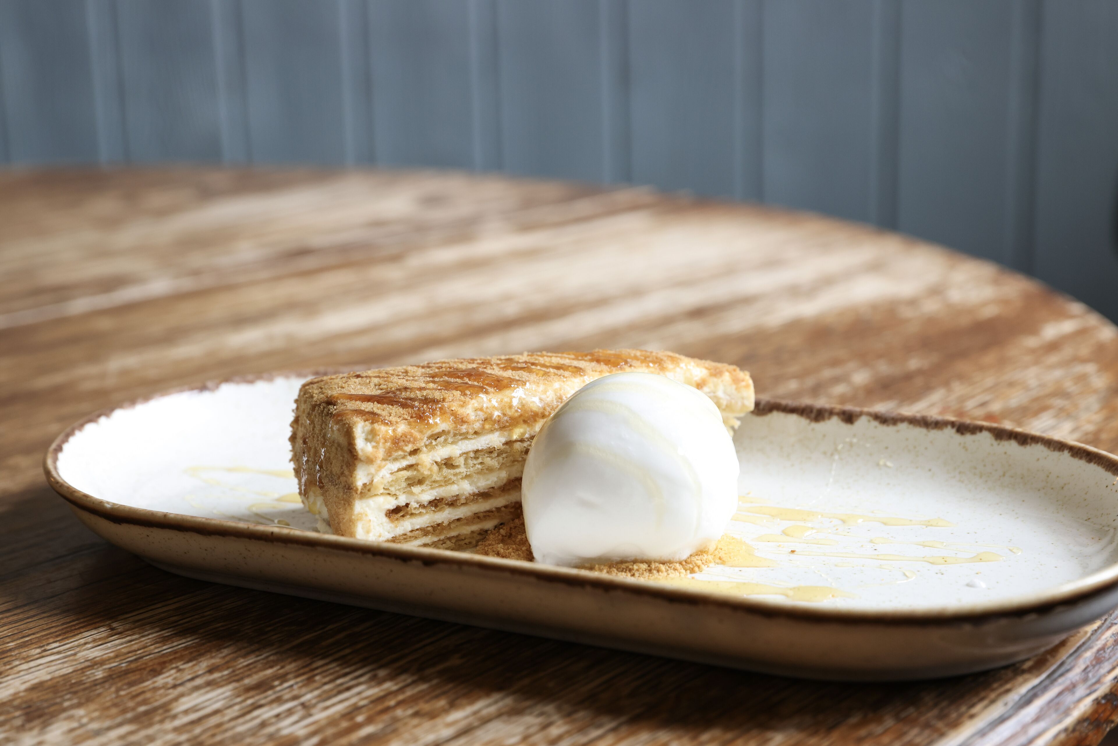 A dessert on a ceramic plate with a wooden table background.