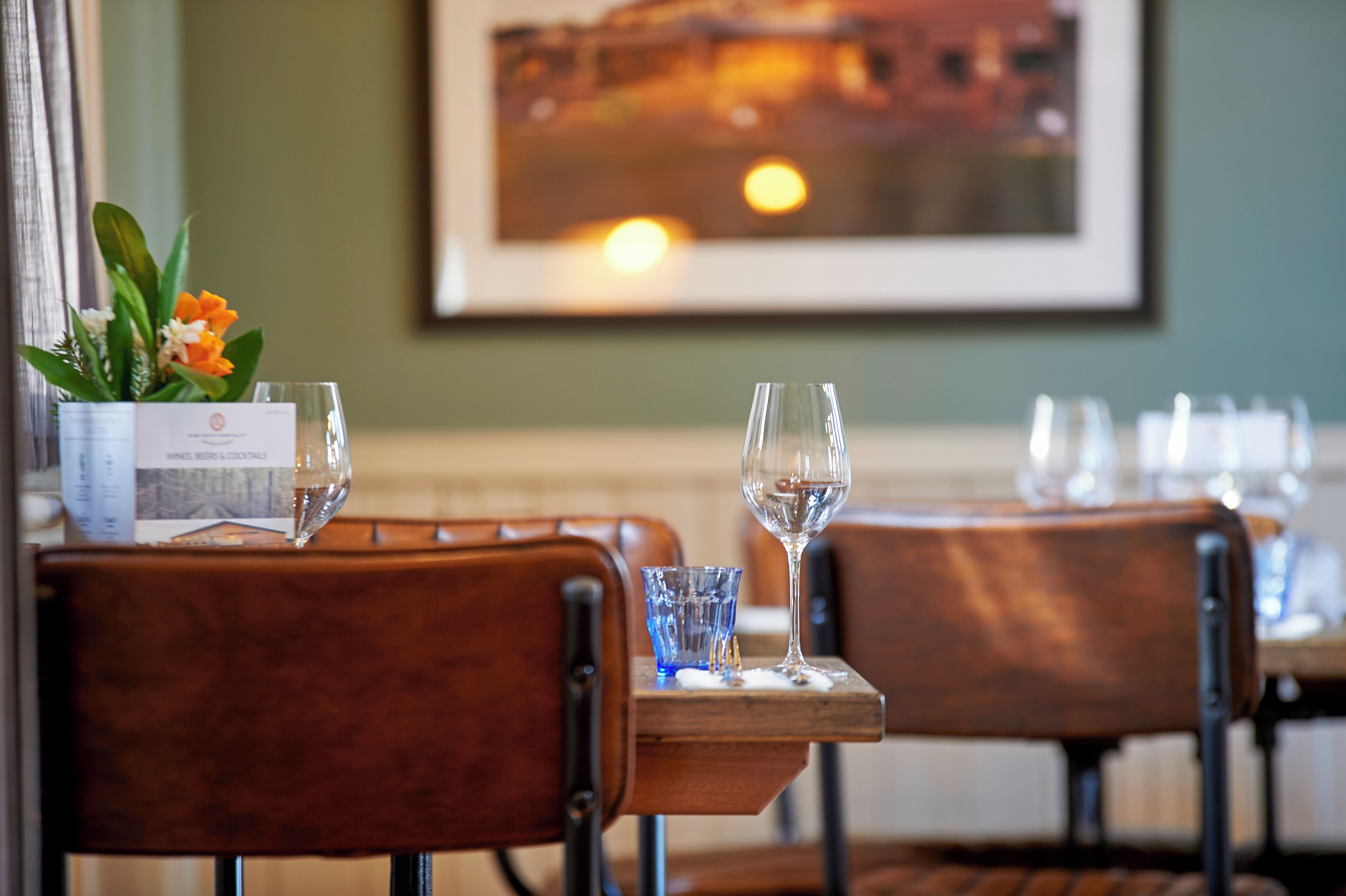 A restaurant setting with wooden chairs and a table set for dining.