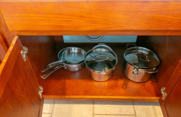 A wooden drawer with stainless steel cookware including pots and pans. - Flirty Flamingo, Too! Garage Apartment with Shared in-ground pool! (Gulfport)