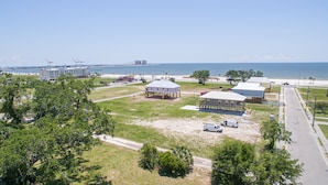 A coastal area with buildings, a beach, and a clear view of the ocean. - Flirty Flamingo, Too! 1 BDR 1BTH, with Shared in-ground pool! (Gulfport)