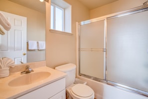 Une salle de bain équipée d’un lavabo, de toilettes et d’une douche à parois en verre.
