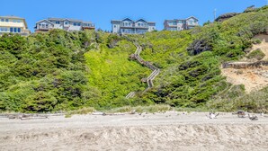 A hillside with a wooden staircase leading to a residential area with multiple houses. - Storm Watchers Pointe (Lincoln City)