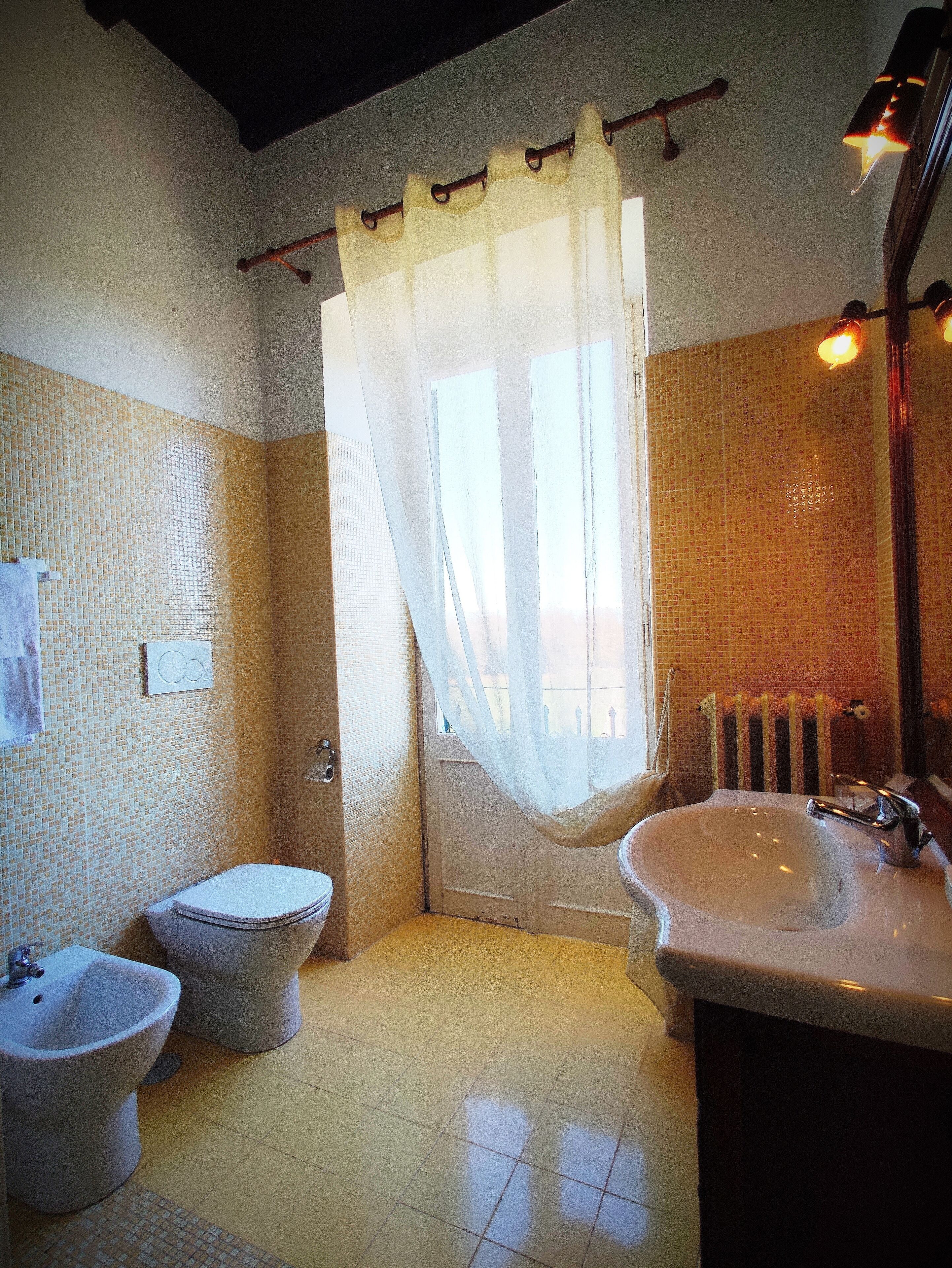 Un baño con inodoro, bidé y lavamanos.