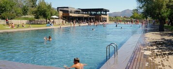Una piscina al aire libre, socorrista en las instalaciones