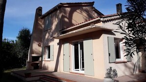 A two-story house with a chimney, a front porch, and a sliding glass door. - Villa under the pines, for 8 or 12 people (adjoining annex in summer) (Six-Fours-les-Plages)