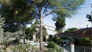 A residential area with a house featuring a tiled roof, a garden with trees and flowers, and a fenced yard. - Villa under the pines, for 8 or 12 people (adjoining annex in summer) (Six-Fours-les-Plages)