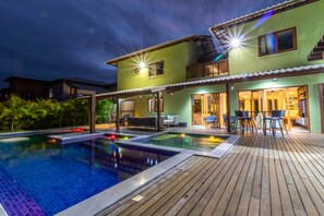 Una piscina al aire libre, sillones reclinables de piscina