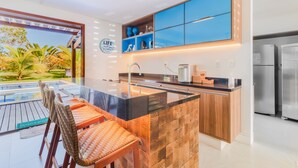 Une cuisine moderne dotée d’un grand îlot central, de meubles bas en bois et de meubles hauts bleus.