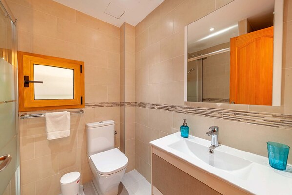 Ein Badezimmer mit Toilette, Waschbecken und Spiegel.