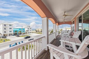 Enjoy the ocean view from this hotel's balcony, featuring comfortable seating and a ceiling fan.