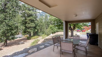 Enjoy al fresco dining on this sheltered patio surrounded by lush trees and a scenic path.