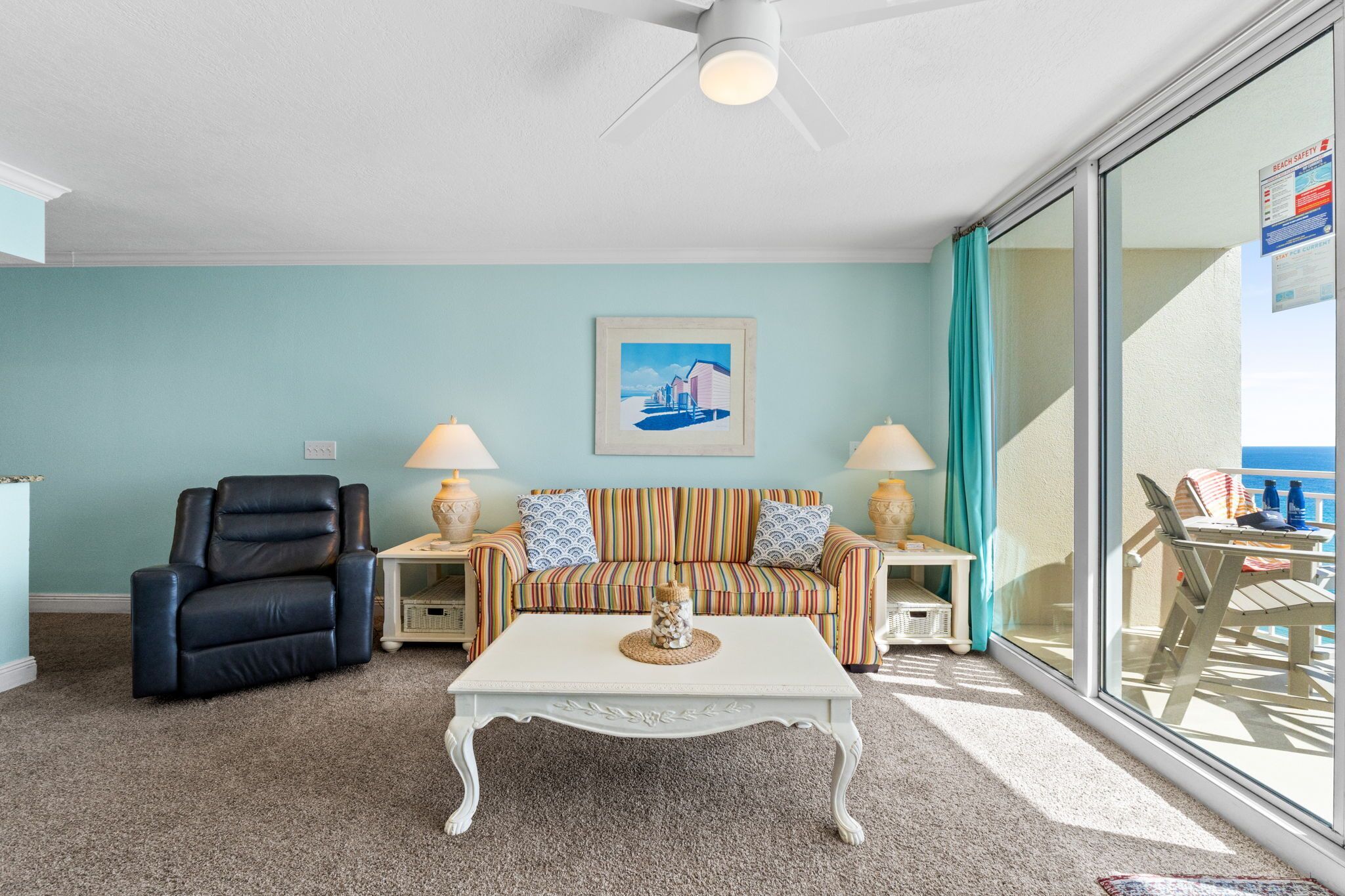 A living room with a sofa, a chair, a coffee table, and a painting on the wall.