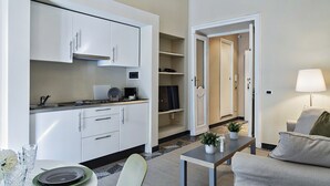 A compact living space with a kitchenette, a dining area, and a seating area. - Via Roma Luxury Apartment (Genova)