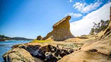 A coastal landscape with prominent rock formations and a clear blue sky.