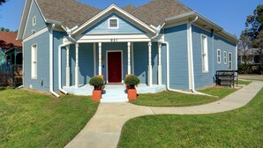 A two-story house with a red door and a number 921 on the front.