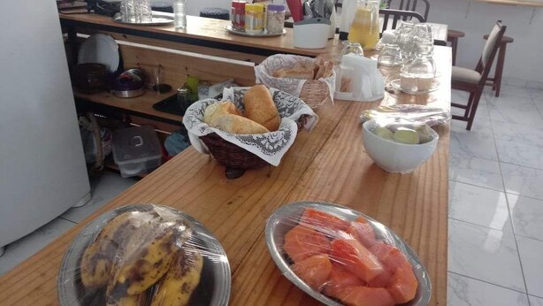 Una encimera de cocina con pan, pescado y un cuenco de lima.