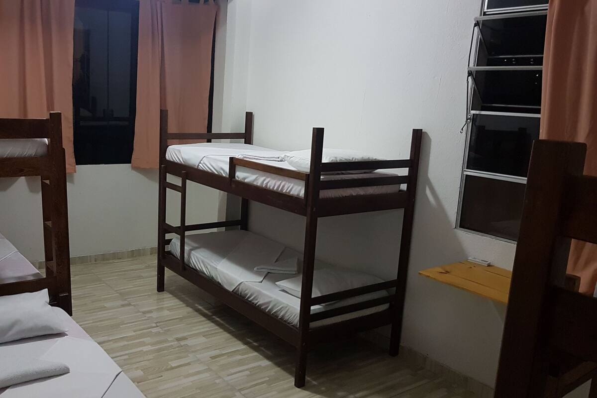Habitación con literas, ventana y cortinas.